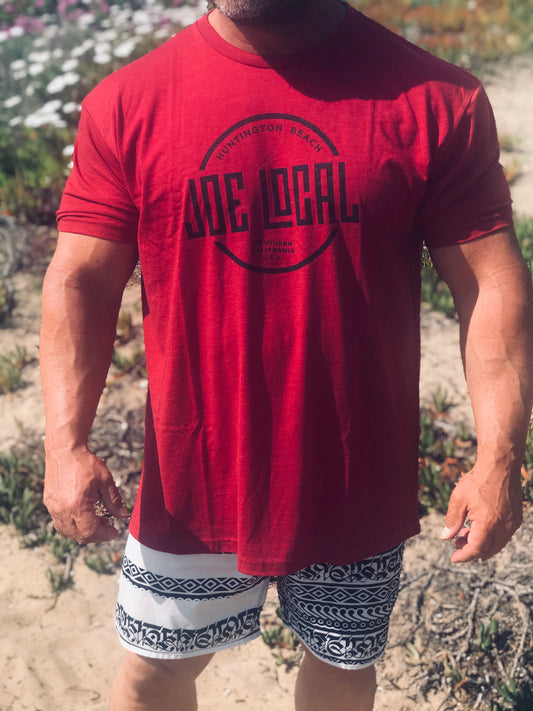 Front of the t-shirt. Joe Local Classic short sleeved Tee In Cardinal Red with Joe Local Huntington Beach/So Cal Circled Logo. Joe Local Logo on upper back centered under the neck.