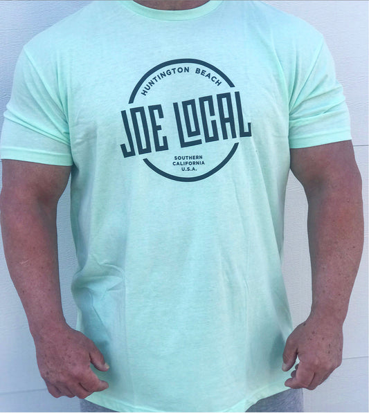 Front of the t-shirt. Joe Local Classic short sleeved Tee In Mint green with Joe Local Huntington Beach/So Cal Circled Logo. Joe Local Logo on upper back centered under the neck.